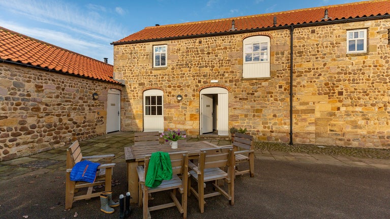 Lapwing and the shared courtyard with picnic benches at the front of the cottage, Yorkshire